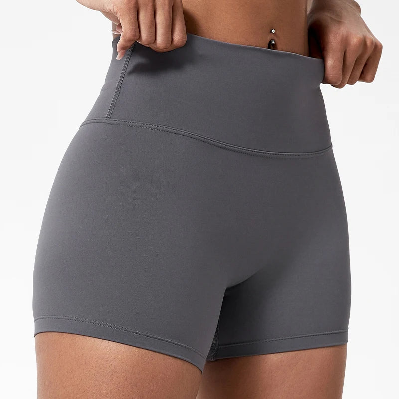 Gros plan d'une femme portant un short de yoga et de sport moulant à taille haute gris.