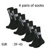 Four pairs of black men's athletic soccer socks with non-slip grip