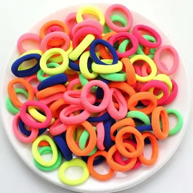 Haufen bunter Nylon-Elastikhaarspangen in leuchtenden Farben wie Pink, Orange, Gelb und Blau