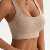 A model wears a beige seamless racerback sports bra top and matching bottoms.