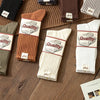 A collection of thick cotton tube socks in various earthy tones including brown, beige, olive green, and white.