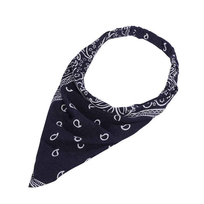 Pañuelo triangular boho paisley azul marino atado al cuello.