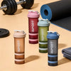 A set of three multi-colored sports shaker bottles with handles and a black fitness mat in the background.
