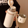 Une bouteille de voyage isotherme en acier inoxydable blanc tenue contre un t-shirt noir.