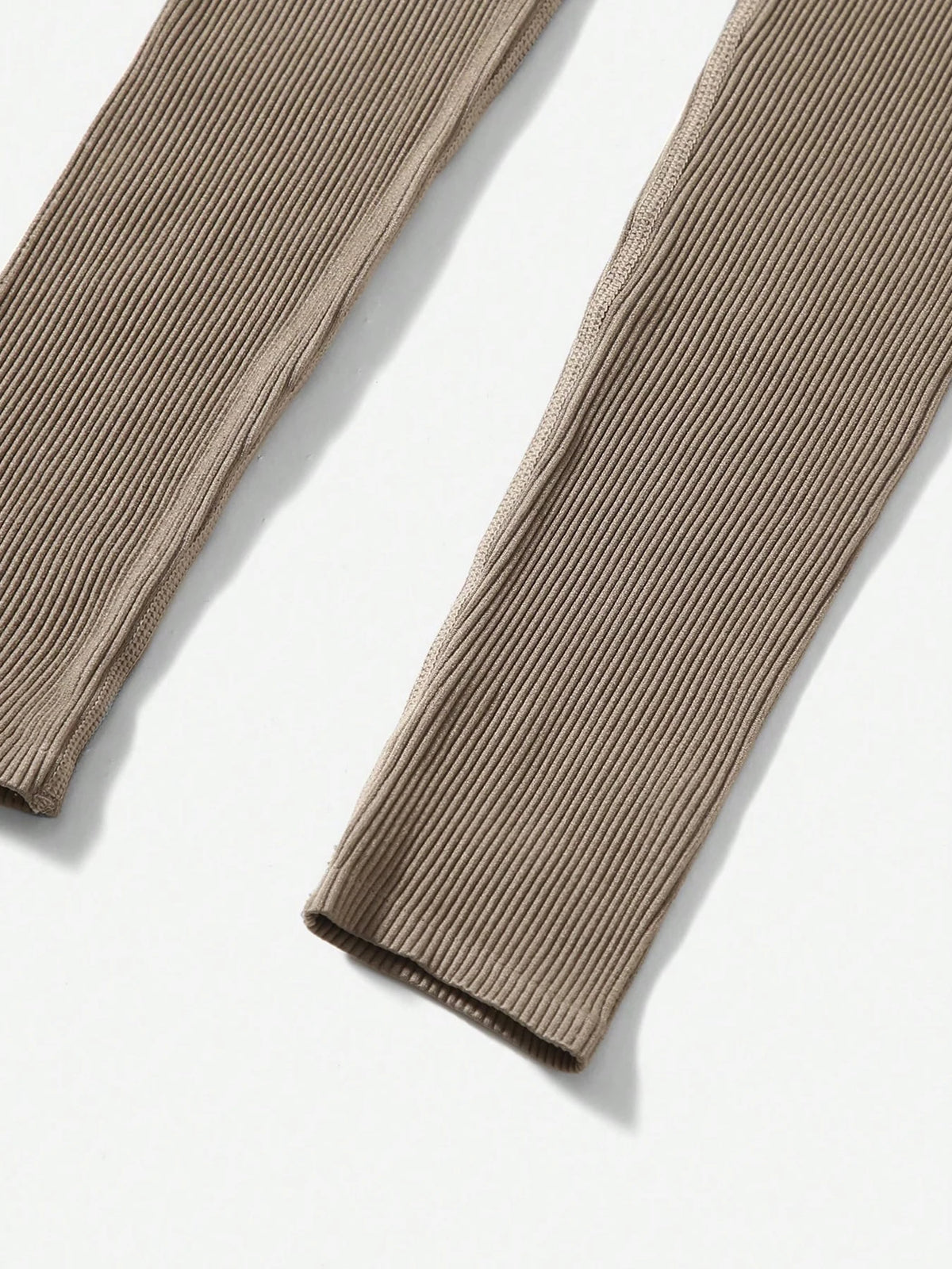 A pair of beige seamless high-waisted yoga leggings shown flat lay.