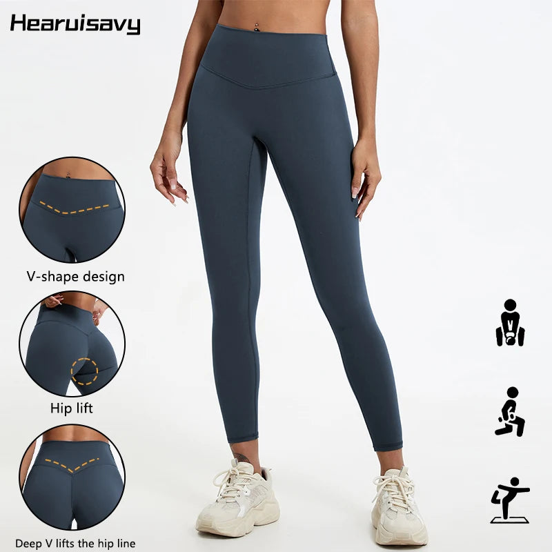 A model wearing dark blue V-shape high-waist yoga leggings demonstrating hip lift features.