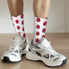 White athletic shoes paired with mid-calf socks featuring a repeating red lip print pattern.