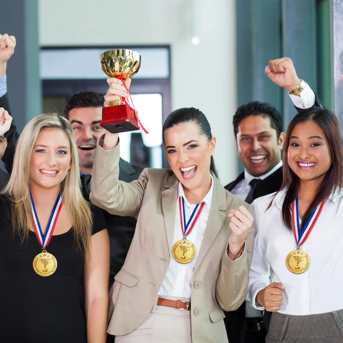 Five women celebrating with gold silver and bronze award medals and ribbons