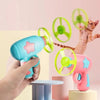 Une main tient un jouet disque volant rose interactif pour chats avec un disque vert tournant sur fond rose clair.