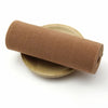 A roll of brown elastic bands used for sewing and decoration, lying next to a wooden disc.