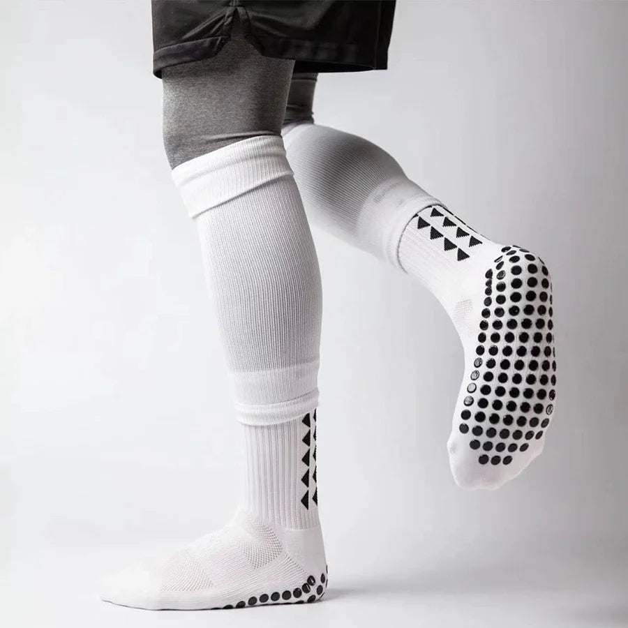 White athletic grip socks with black patterned toes and cuff, worn by a person.