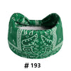 A dark green boho print cotton headband tied in a bow.