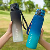 Eine Hand hält eine graduierte isolierte Wasserflasche, die von hellgrau zu leuchtend blau übergeht.