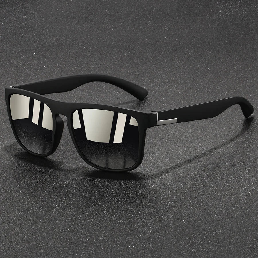 Black vintage designer square sunglasses resting on a dark surface.