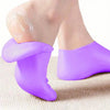 Purple silicone moisturizing socks being worn on a foot.