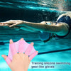 Hand wearing pink silicone swimming gear-like gloves in clear blue water.