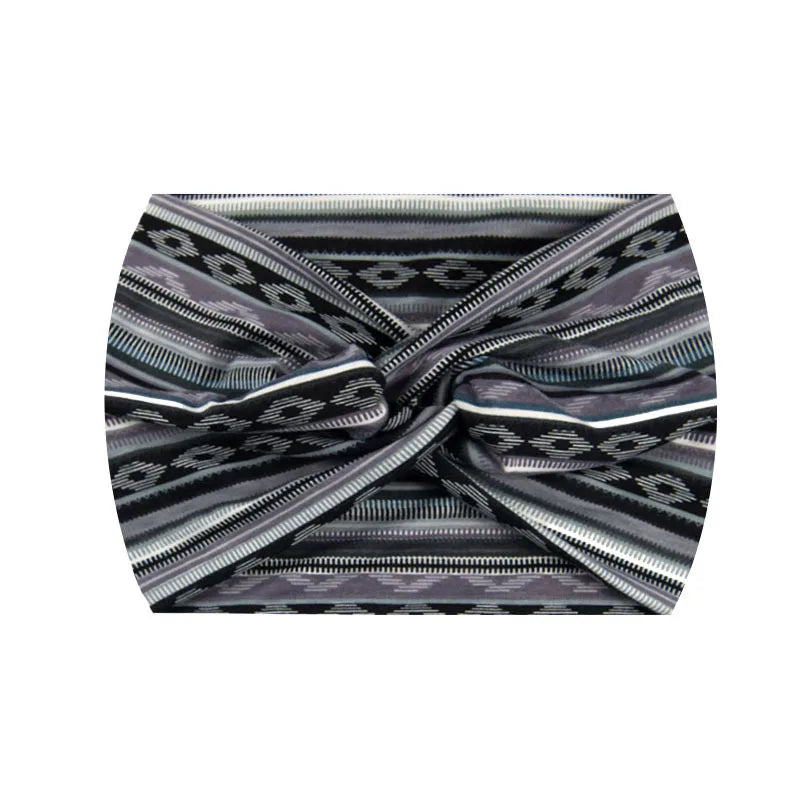 A close-up of a grey and black striped boho printed wide knotted headband.