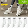 Five pairs of white socks with black stripes shown on legs and individual view.