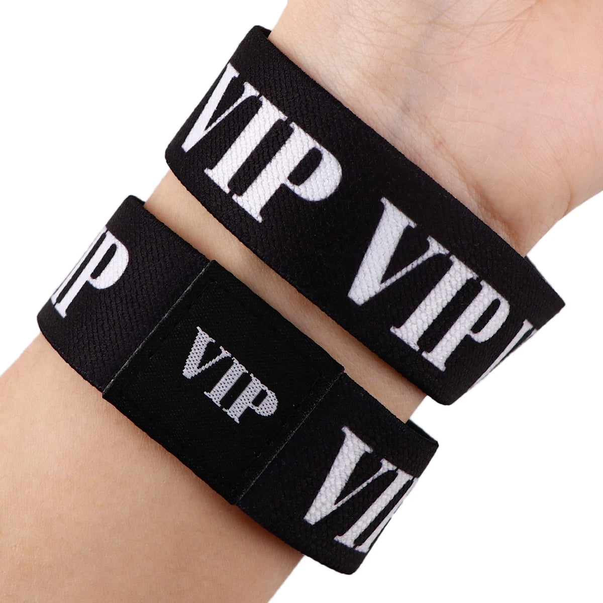 Schwarz-weiß VIP-Seilarmbänder am Handgelenk getragen.