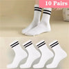 Ten pairs of white socks with black stripes shown on a hand.