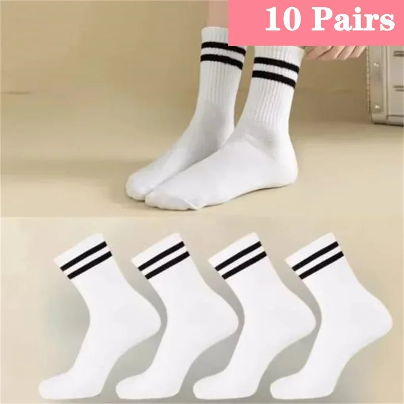 Ten pairs of white socks with black stripes shown on a hand.