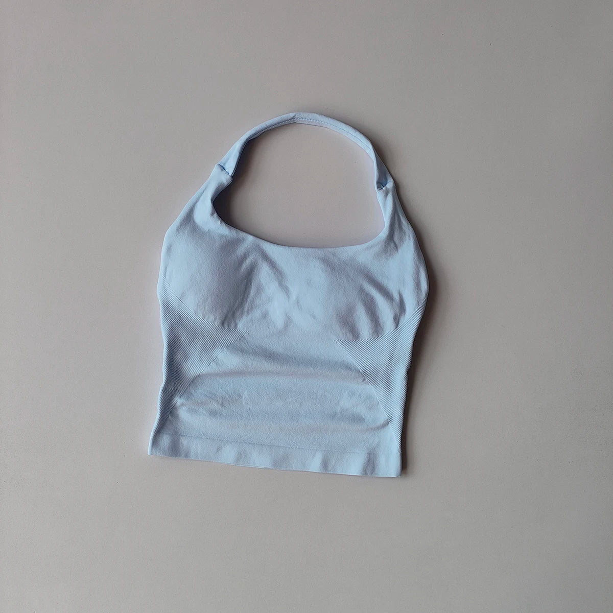 Un haut sans coutures bleu clair à bretelles affiché sur un fond neutre.