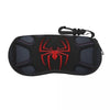 Black neoprene pouch with a red spider web design and a black strap for storing eyeglasses.