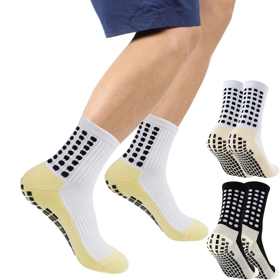 A pair of white and black grip socks worn on a person's foot.