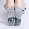 Pair of gray silicone yoga and fitness socks with textured toes and a contrasting dark gray heel.