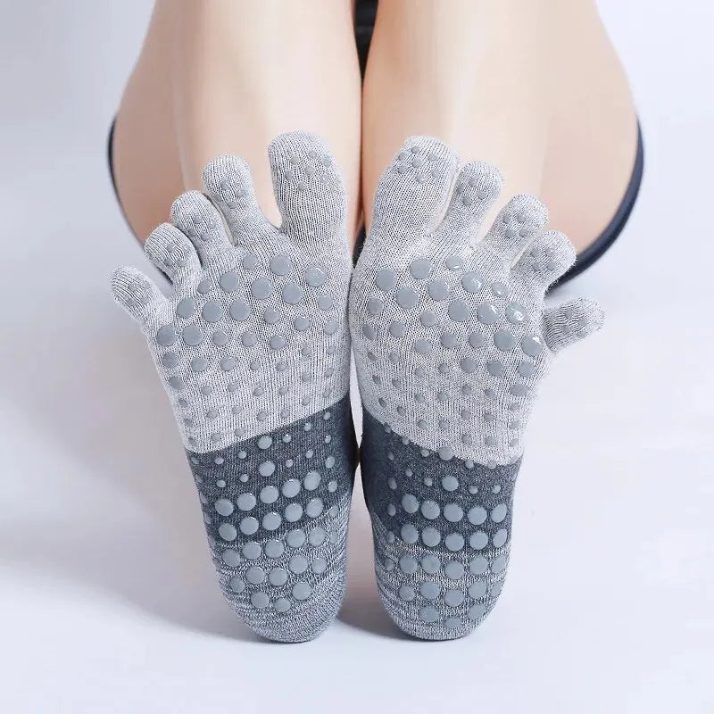 Pair of gray silicone yoga and fitness socks with textured toes and a contrasting dark gray heel.