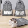 Gray reusable non-woven shoe storage bags with white sneakers displayed on a wooden surface.