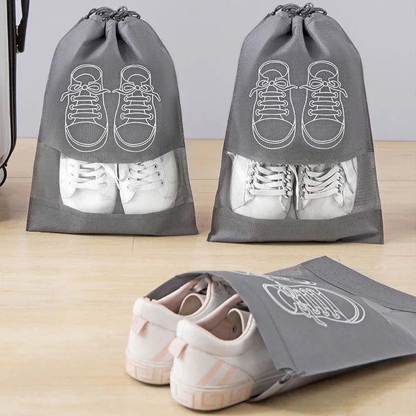 Gray reusable non-woven shoe storage bags with white sneakers displayed on a wooden surface.