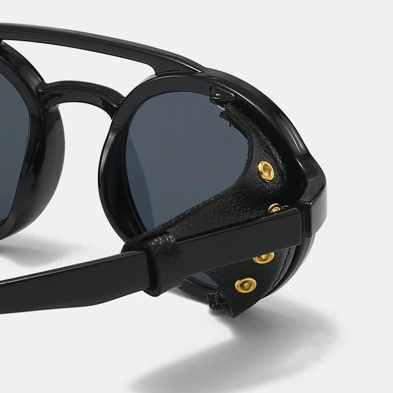 Black retro steampunk goggles sunglasses with gold accents shown in a close-up view.