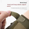 Close-up of a hand adjusting the elastic hook and loop wrist strap on a tactical glove.