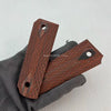 A hand holds a rosewood DIY knife grip patch, showing its textured surface and mounting holes.
