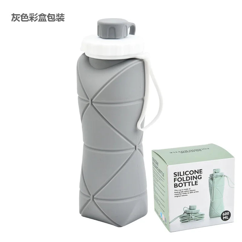 A gray silicone folding bottle with a white cap and strap, shown next to its packaging box.