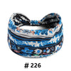 A patterned fabric turban headband featuring blue, white, and black floral designs.
