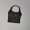 Haut sans couture noir à col, pour yoga et fitness, présenté sur fond gris clair.