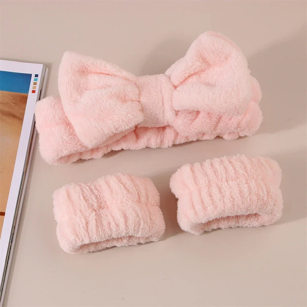 A set of pink microfiber spa headband and wristbands shown on a light background.
