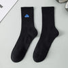 A pair of black men's athletic crew socks with a blue embroidered logo on the heel.