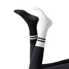 A pair of black and white non-slip yoga socks shown vertically.