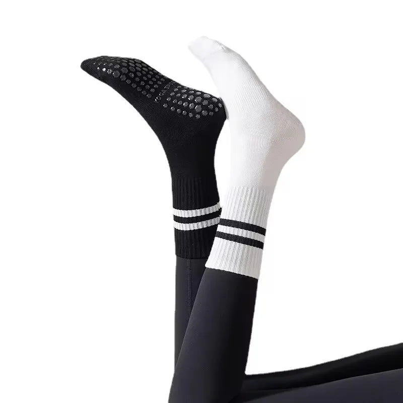 A pair of black and white non-slip yoga socks shown vertically.
