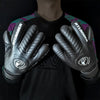 A pair of black latex goalkeeper gloves with silver accents and the Atlanta United logo on the wrist.