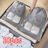 A gray reusable non-woven shoe storage bag with white shoes is shown inside a storage box.
