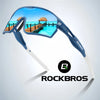 A pair of blue polarized cycling sunglasses with white arms and a Rockbros logo, set against a tropical sea background.