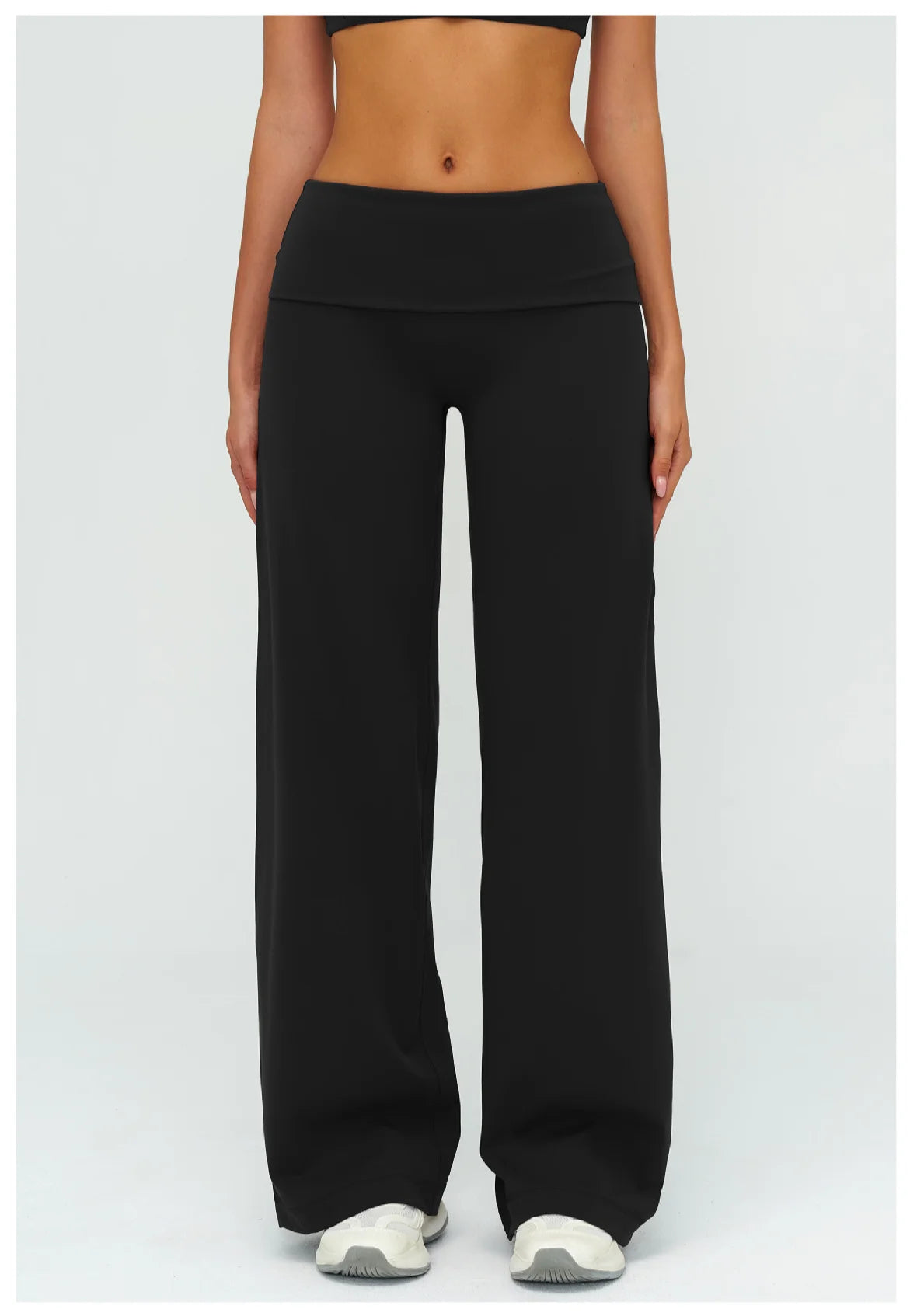 A model wearing black flared high-waist yoga pants and a black sports bra top.