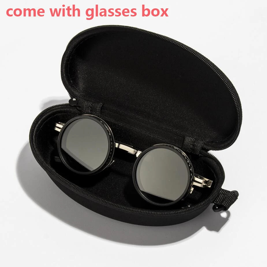 A black velvet box containing a pair of round sunglasses with silver frames and lenses.