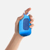 A hand is holding a blue cooling towel with a mesh texture and a blue strap.