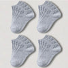 Un juego de calcetines unisex de algodón transpirable color gris claro, mostrados en cuatro ángulos diferentes.