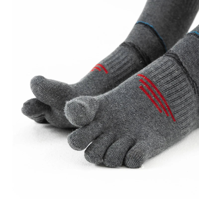 A close-up of a gray men's sport compression sock on a hand and foot, showing red stitching.